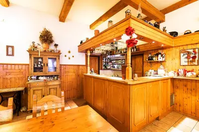 a large kitchen with wooden cabinets and a bar at Pension U Dvou čápů in Chocerady