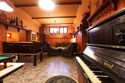 a room with a piano and a table and chairs at Pension U Dvou čápů in Chocerady