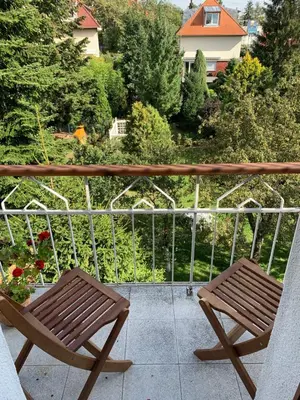 a pair of wooden chairs sitting on a balcony at Residence Sarka in Prague