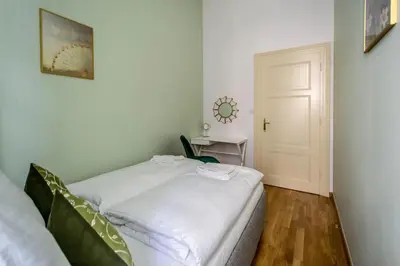 a small bedroom with a white bed and a desk at Design 3BDR Apartment in residence, FREE PARKING in Prague