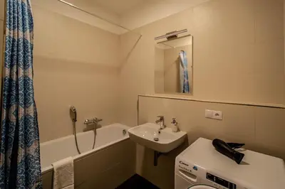 a small bathroom with a sink and a bath tub at Design 3BDR Apartment in residence, FREE PARKING in Prague