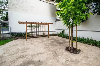 a tree and a wooden structure next to a building at Design 3BDR Apartment in residence, FREE PARKING in Prague