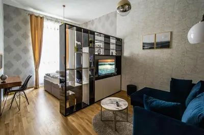 a living room with a blue couch and a tv at Design 3BDR Apartment in residence, FREE PARKING in Prague