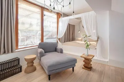 a living room with a chair and a bed at Holečkova Apartments in Prague