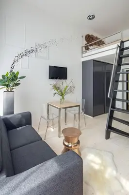 a living room with a chair and a couch and a mirror at Holečkova Apartments in Prague