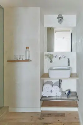 a white living room with a table and a couch at Holečkova Apartments in Prague