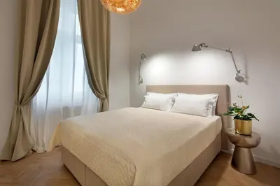 a bedroom with a large white bed with two pillows at Holečkova Apartments in Prague