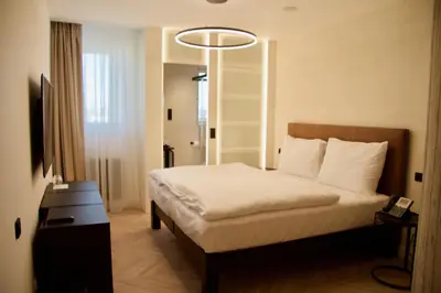 a hotel room with a bed and a chandelier at Chevron Hotel in Prague