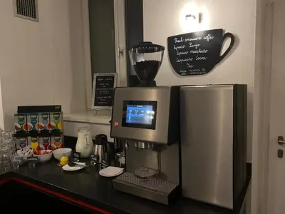 a kitchen counter with a coffee maker and a refrigerator at Chevron Hotel in Prague