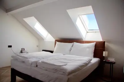 a bedroom with a bed with two skylights at Chevron Hotel in Prague