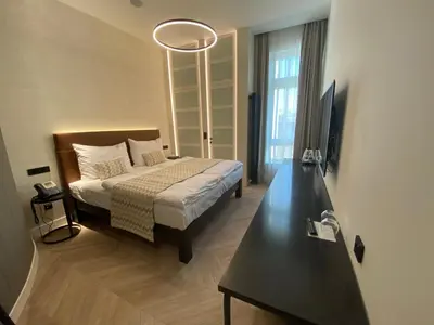 a bedroom with a bed and a desk with a television at Chevron Hotel in Prague