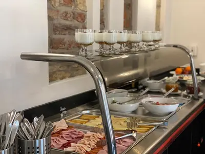 a buffet line with glasses of wine and food at Chevron Hotel in Prague