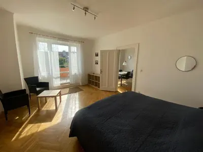 a bedroom with a bed and a table and a chair at Vila Malvazinky in Prague