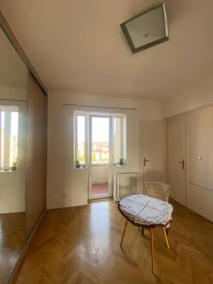 an empty living room with a table and a window at Vila Malvazinky in Prague