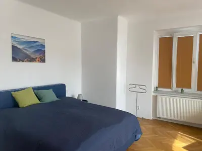 a bedroom with a blue bed and a window at Vila Malvazinky in Prague