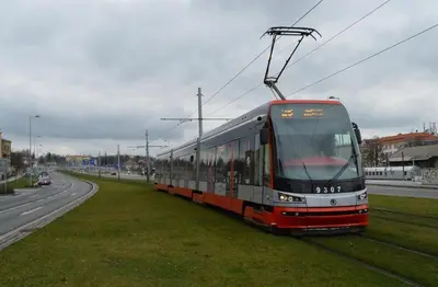 a tram is on the grass next to a road at Cozy room at metro station, private bathroom, 9minutes oldtown, 15minutes airport, WiFi in Prague