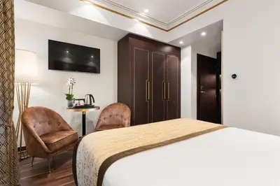 a bedroom with a bed and two chairs and a table at Áurea Legends by Eurostars Hotel Company in Prague