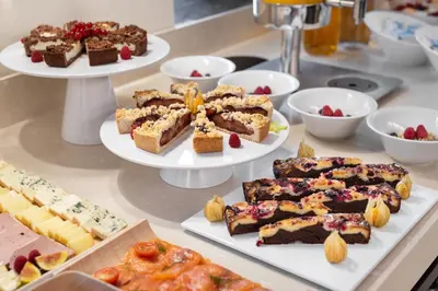 a buffet with different types of desserts on plates at Áurea Legends by Eurostars Hotel Company in Prague