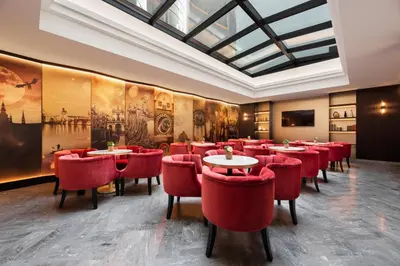 a restaurant with red chairs and tables in a room at Áurea Legends by Eurostars Hotel Company in Prague