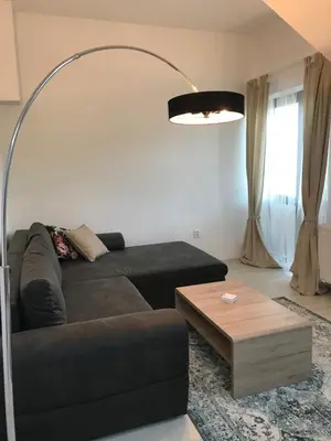 a living room with a black couch and a table at Apartman Harmonia Poděbrady 60m2 in Poděbrady