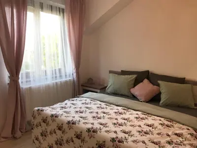 a bedroom with a bed with a floral blanket at Apartman Harmonia Poděbrady 60m2 in Poděbrady