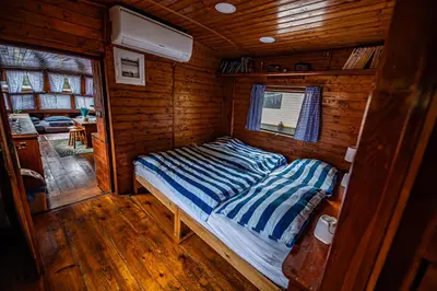 a bedroom with a bed in a wooden cabin at Prague Bay Houseboats in Prague