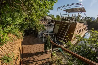 a wooden dock with a boat in a river at Prague Bay Houseboats in Prague