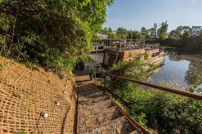 a staircase leading down to a river next to a brick wall at Prague Bay Houseboats in Prague