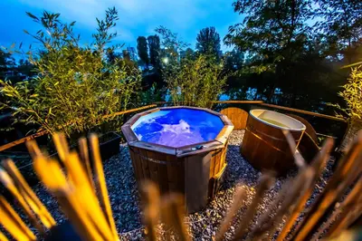 a hot tub and a trash can in a garden at Prague Bay Houseboats in Prague