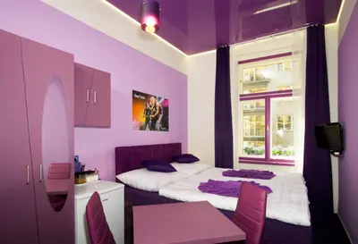 a purple room with two beds and a window at Apartment COLOURS - your 7 colour experience in centre of Prague in Prague