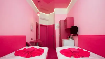 two beds in a room with pink walls at Apartment COLOURS - your 7 colour experience in centre of Prague in Prague