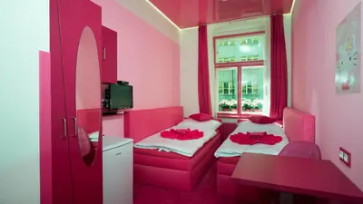 a pink room with a bed and a window at Apartment COLOURS - your 7 colour experience in centre of Prague in Prague