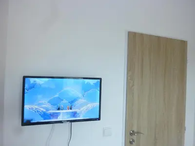 a flat screen tv hanging on a white wall at Apartmán VAN NG in Prague