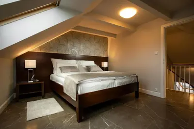 a bedroom with a large bed with a wooden headboard at Hotel Anna in Beroun