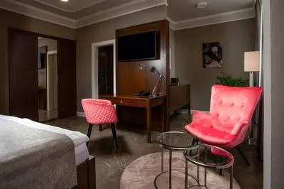 a hotel room with a bed and a desk and chairs at Hotel Anna in Beroun