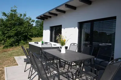 a black table and chairs on a patio at Wellness bungalov - vodní nádrž Slapy - 40km od Prahy in Nečín