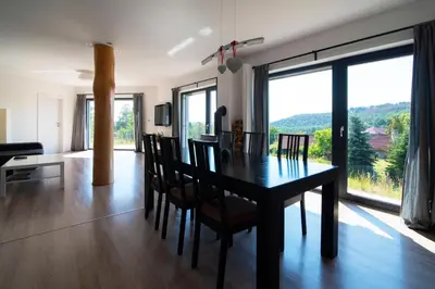 a dining room and living room with a table and chairs at Wellness bungalov - vodní nádrž Slapy - 40km od Prahy in Nečín