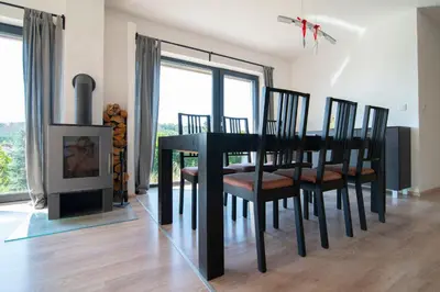a dining room with a table and chairs and a fireplace at Wellness bungalov - vodní nádrž Slapy - 40km od Prahy in Nečín
