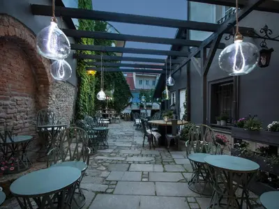 an outdoor patio with tables and chairs and lights at Cathedral Prague Apartments in Prague
