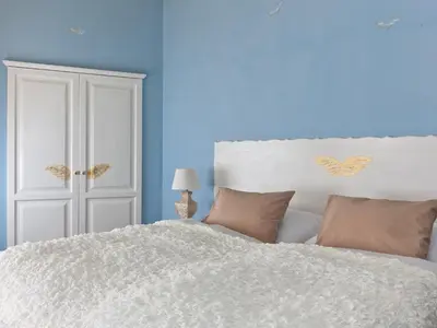 a bedroom with a white bed with blue walls at Cathedral Prague Apartments in Prague