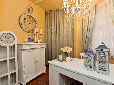 a room with a table and a clock and a chandelier at Cathedral Prague Apartments in Prague