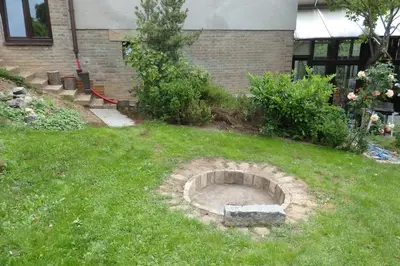 a garden with a stone circle in the grass at Prague Gardens Appartments in Prague