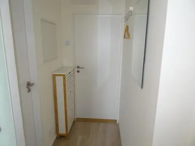 a hallway with a white door and a wooden floor at Prague Gardens Appartments in Prague