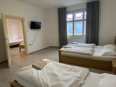 a bedroom with two beds and a tv on the wall at KK Apartments in Prague