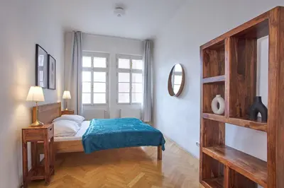 a bedroom with a bed and a large window at Charles Bridge Apartments in Prague