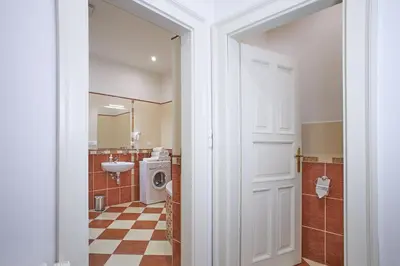 a bathroom with a sink and a washing machine at Charles Bridge Apartments in Prague