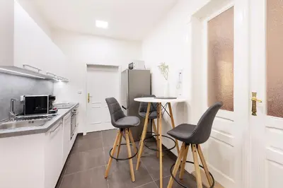 a kitchen with stools and a table and a refrigerator at Prague Roof Apartments in Prague