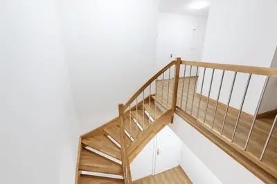 a wooden staircase in a room with white walls at Prague Roof Apartments in Prague