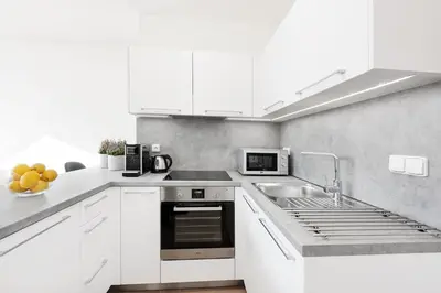 a white kitchen with a sink and a stove at Prague Roof Apartments in Prague