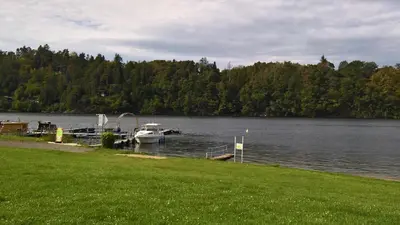 a boat is docked at a dock on a lake at Holiday home Zajícovi in Rabyně